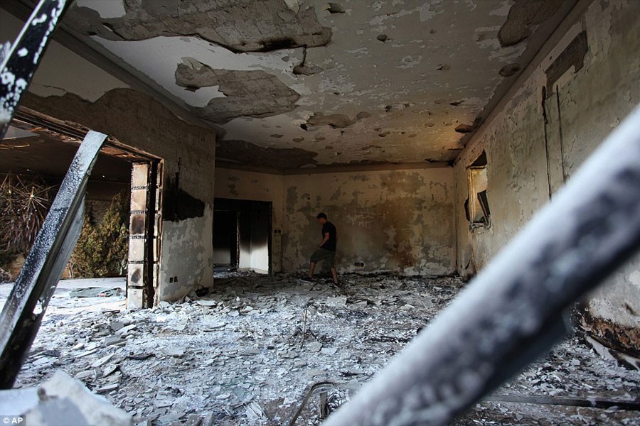 A Libyan man walks in the rubble of the damaged building after a crowd of hundreds attacked the consulate, many of them firing machine-guns and rocket-propelled grenades  (AP photo)