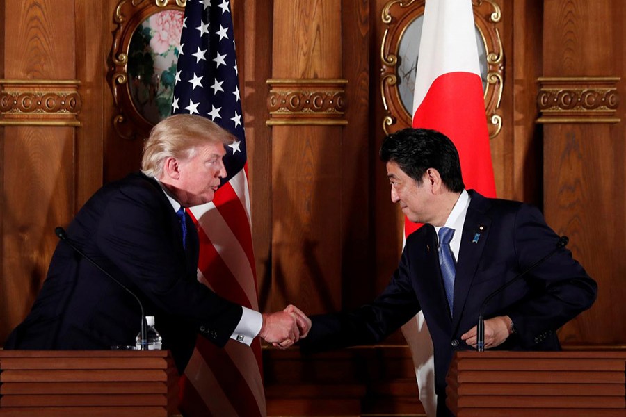 US President Donald Trump and Japan's Prime Minister Shinzo Abe shake hands during a news conference in Tokyo, Japan on Monday. - Reuters photo