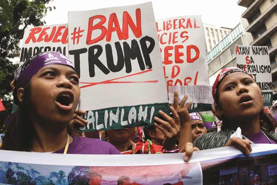 Activists display placards during a rally near the US embassy in Manila, November 09, 2017.