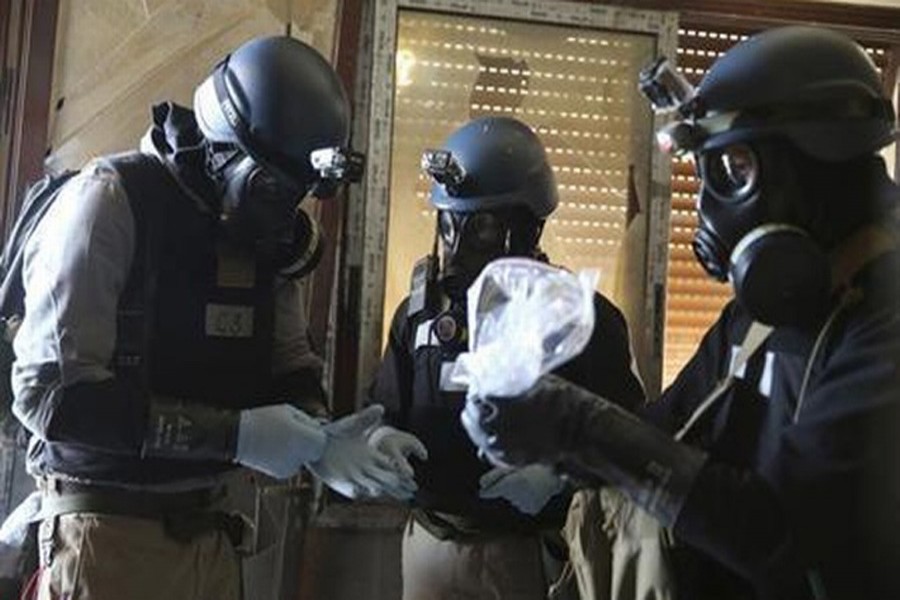 A UN chemical weapons expert, wearing a gas mask, holds a plastic bag containing samples from one of the sites of an alleged chemical weapons attack in the Ain Tarma neighbourhood of Damascus Aug 29, 2013. Reuters