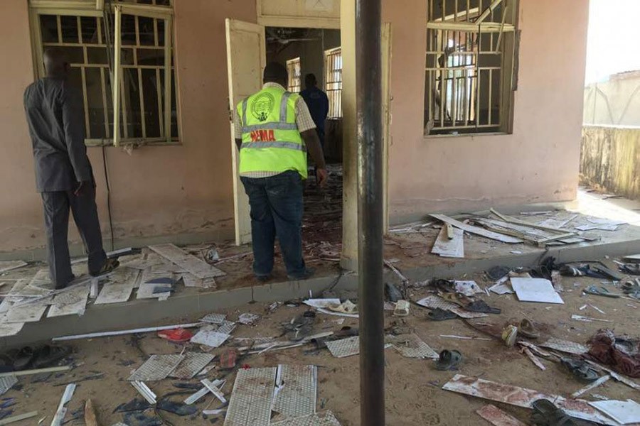 A National Emergency Management Agency (NEMA) staff inspects the damage at the site of a suicide bomber attack in Mubi in Adamawa state, in northeastern Nigeria on Tuesday. - Reuters