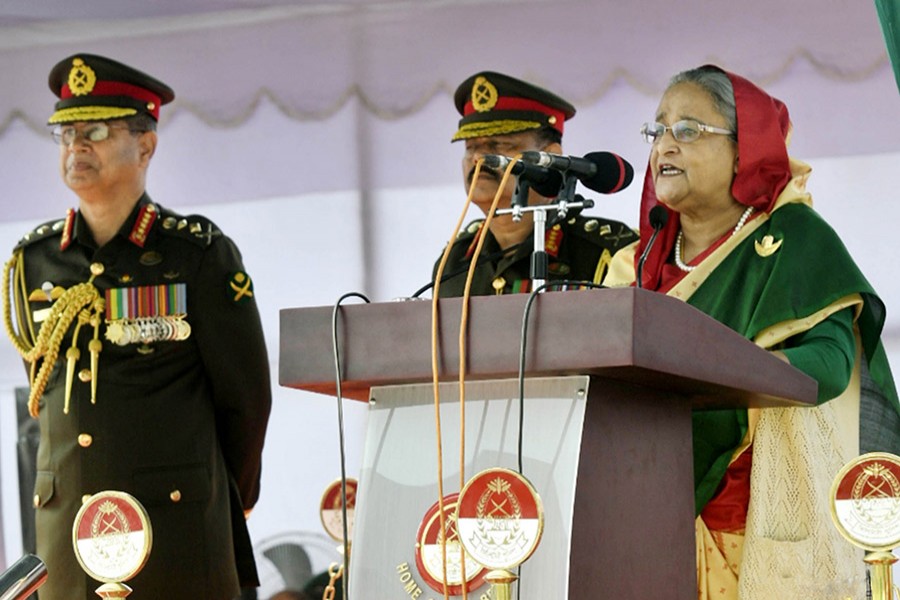 Prime Minister Hasina seen addressing a parade marking the handover of National Standard (national flag) to the Corps of Military Police (CMP) Centre at Savar Cantonment on Thursday. - Focus Bangla.