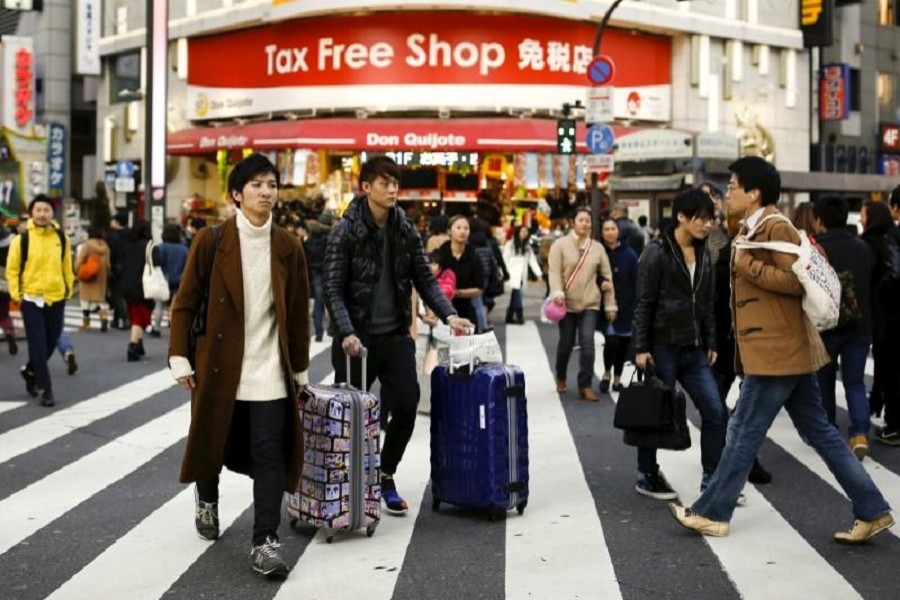 People cross a street outside a tax-free department store popular among Chinese tourists in Tokyo, Japan, February 11, 2016. Reuters/Files