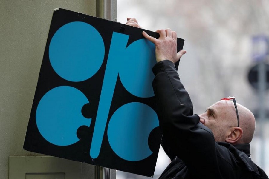 A man fixes a sign with OPEC's logo next to its headquarter's entrance before a meeting of OPEC oil ministers in Vienna, Austria, November 29, 2017. Reuters