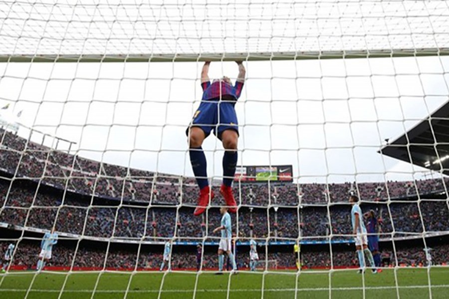 Barcelona’s Paco Alcacer swings on the crossbar after missing a chance to score. - Reuters photo