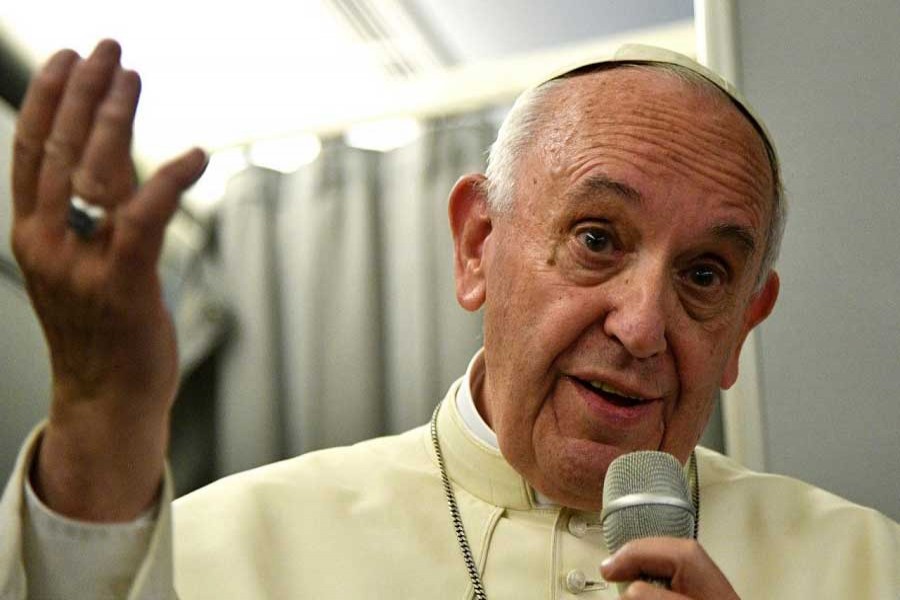 Pope Francis gestures during a news conference on board of the plane during his flight back from a trip to Myanmar and Bangladesh, December 2, 2017. Reuters