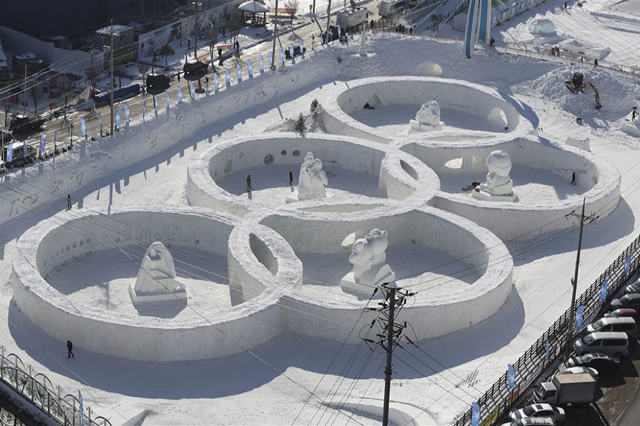 Visitors tour near a snow sculpture in the shape of the Olympic rings during the Daegwanryung Snow Festival in Pyeongchang, South Korea, on February 3, 2017. - AP photo