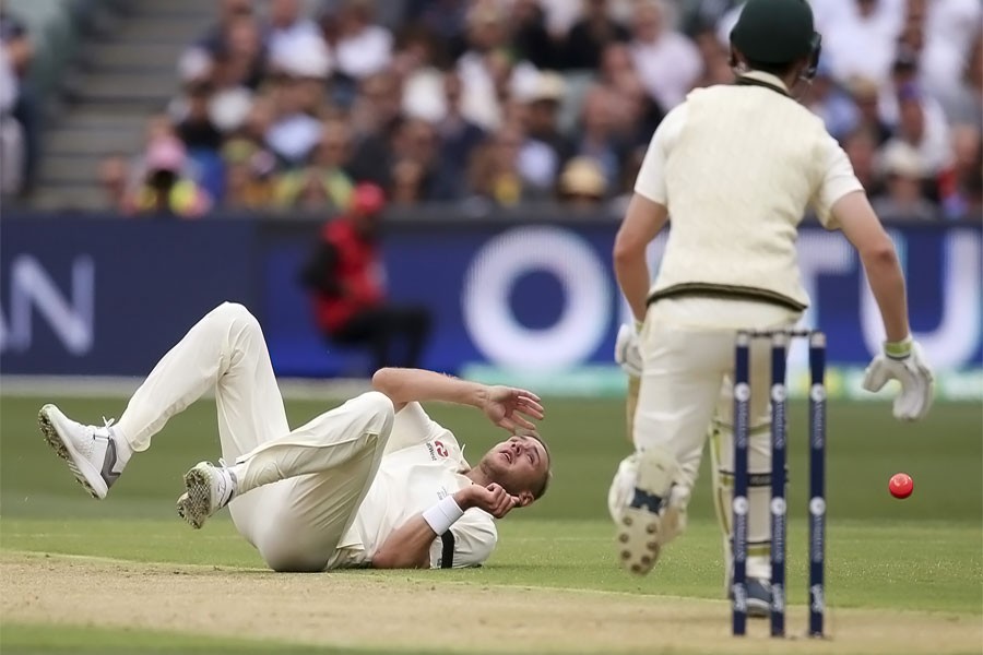 England's Stuart Broad, left, rolls on the ground in attempt to field off his own bowling to Australia's Cameron Bancroft during their Ashes test match in Adelaide, Saturday, Dec. 2, 2017. (AP photo)