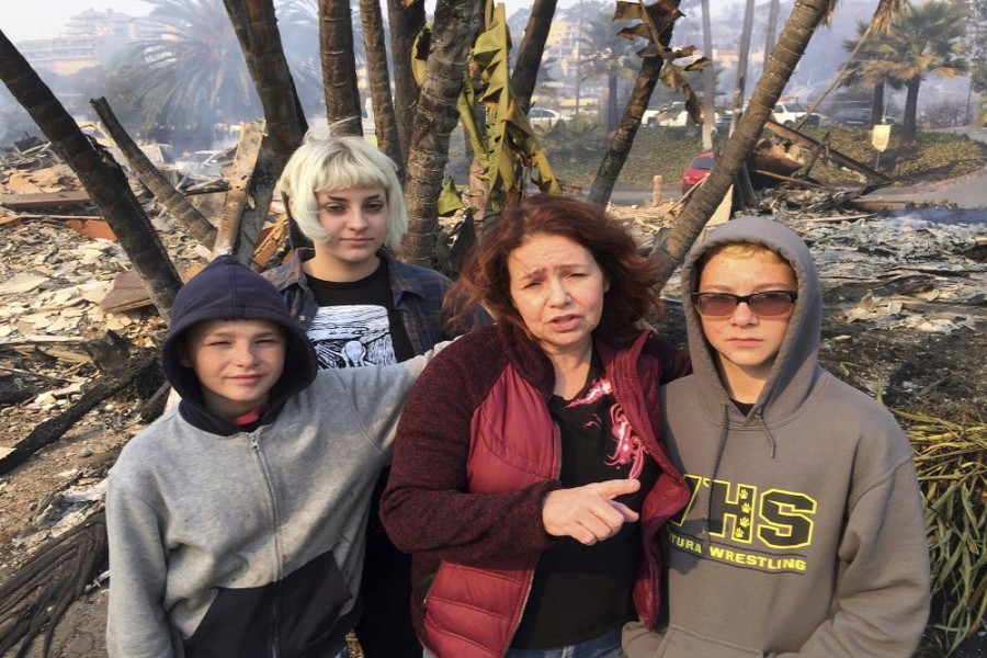 Lisa Kermode, second from right, and her children, from left, Damien, Lola and Michael, pose outside the ruins of their home after a wildfire swept through Ventura.Photo: AP