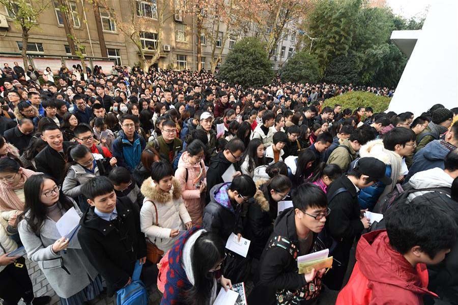 Examinees walk into Nanjing Forestry University to take the National Civil Servant Exam in Nanjing, east China's Jiangsu Province, Dec 10, 2017.