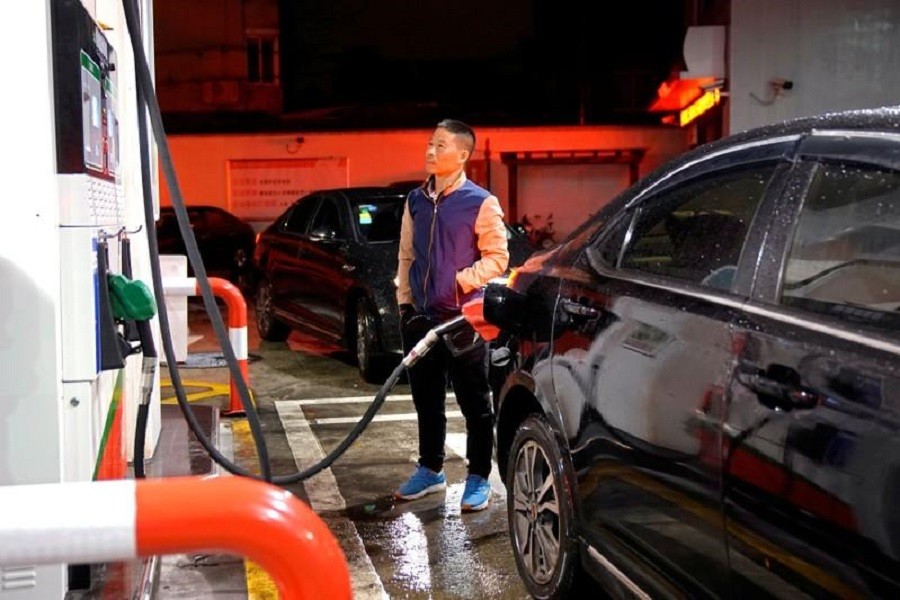 A driver looks at the price as he fills the tank of his car at a gas station in Shanghai, China November 17, 2017. Reuters