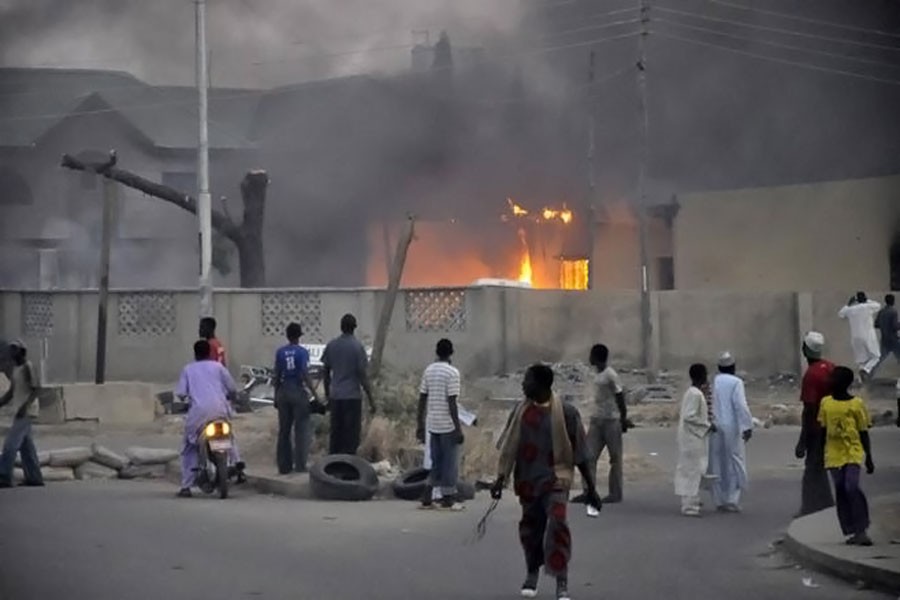 People watch as smoke rises from the police headquarters in Nigeria’s northern city of Kano after a bomb attack on January 20, 2012. ( Reuters photo used for representational purpose)