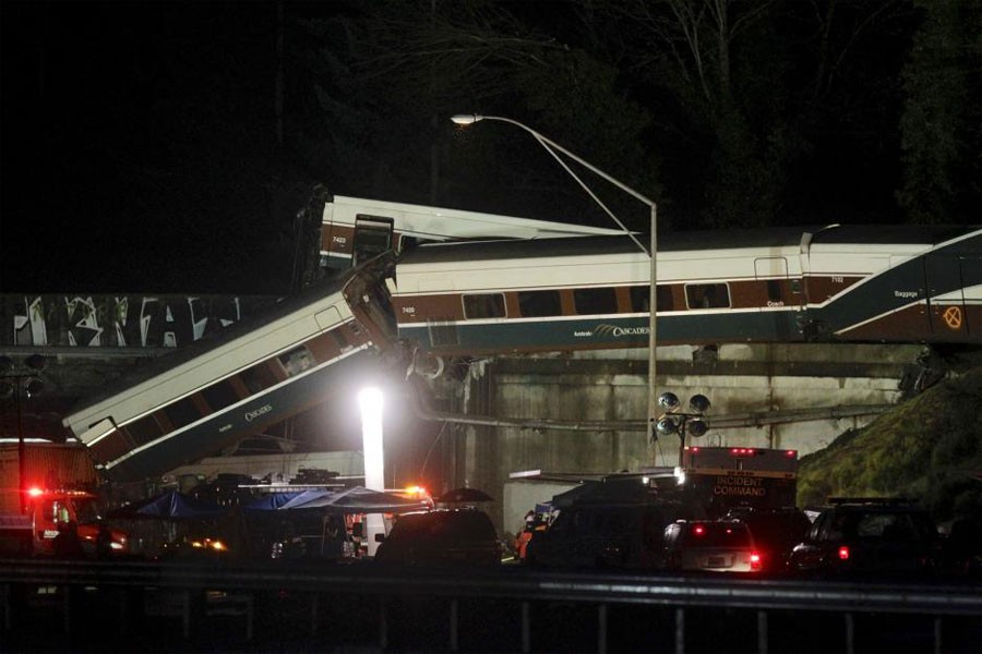 Rescue personnel and equipment are seen working into darkness at the scene where an Amtrak passenger train derailed on a bridge over interstate highway I-5 in DuPont, Washington, US. December 18, 2017.