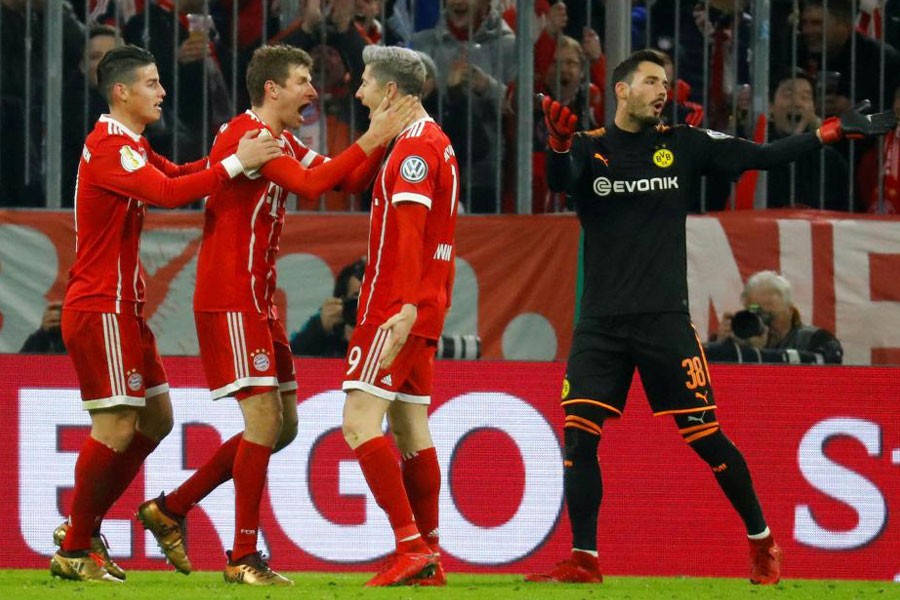 DFB Cup Third Round - Bayern Munich vs Borussia Dortmund - Munich, Germany - December 20, 2017. Bayern Munich's Thomas Muller celebrates scoring their second goal with Robert Lewandowski and James Rodriguez. (Reuters)