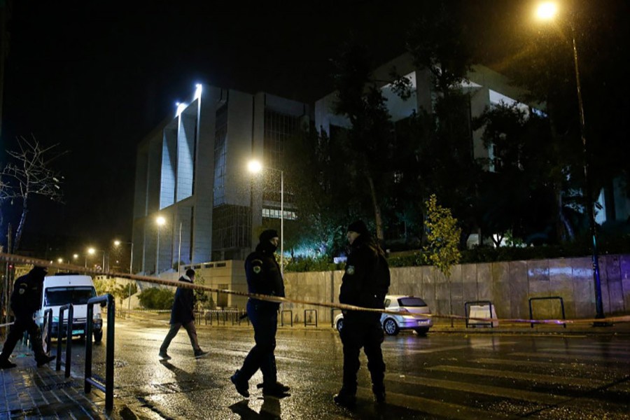 Greek policemen secure the area after a bomb blast at a court building in Athens, Greece on Friday. - Reuters