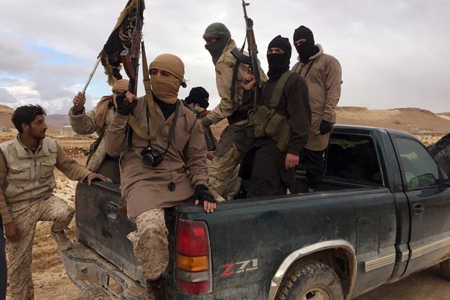 Al Qaeda fighters carry their weapons on the back of a pick-up truck in Lebanon two years ago. -Reuters Photo