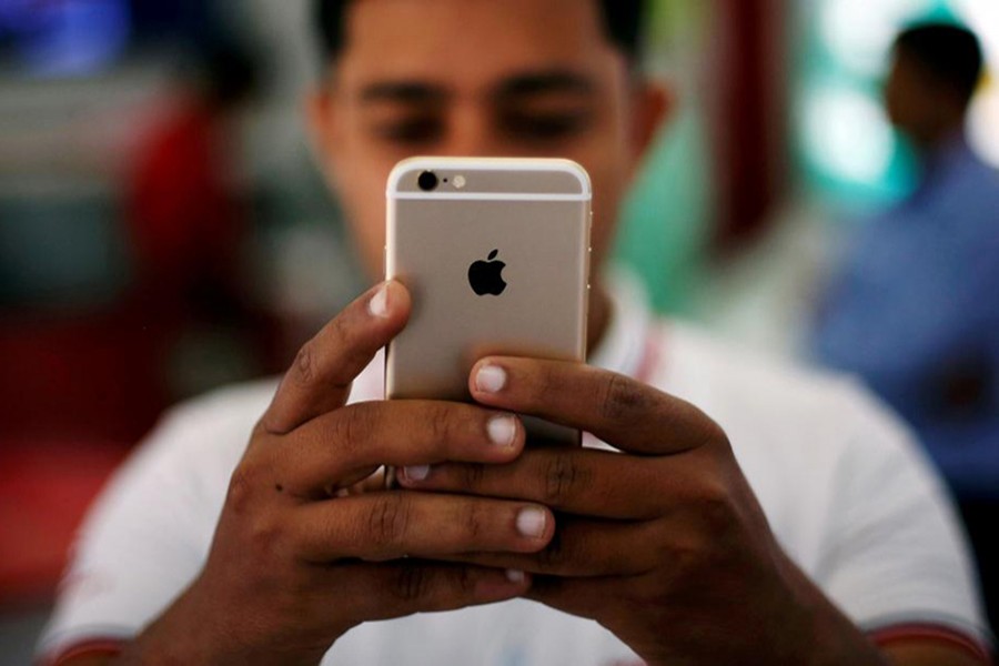 A salesman checks a customer's iPhone at a mobile phone store in New Delhi, India, July 27, 2016. - Reuters file photo