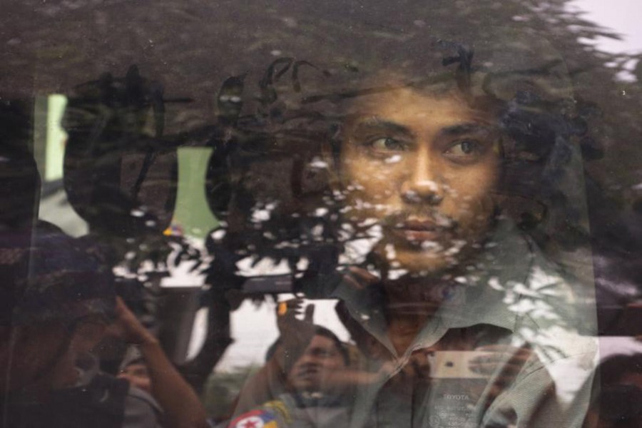 Reuters reporter Kyaw Soe Oo looks out from a police vehicle as he leaves a court in Yangon, Myanmar on Wednesday. - Reuters photo