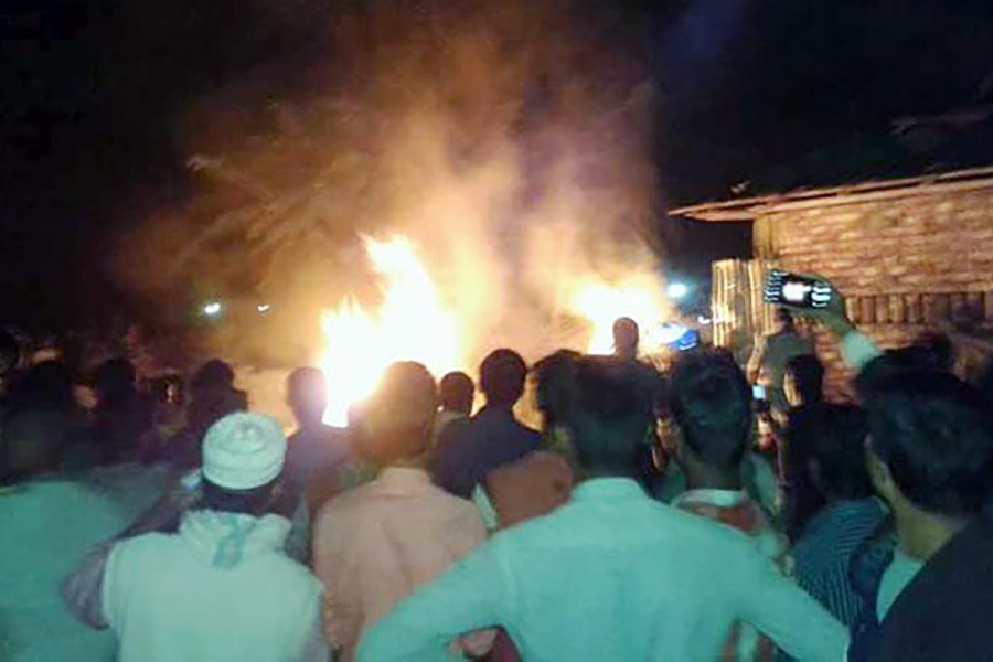 Locals gather at a spot of Cox's Bazar where two training aircrafts crashed on Wednesday.