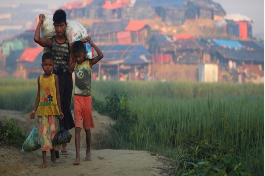 Rohingya refugee children carry supplies through Balukhali refugee camp near Cox's Bazar, Bangladesh, October 23, 2017. Reuters.