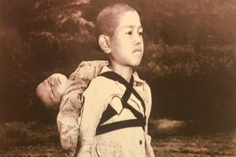 A Japanese child carries the body of his brother.	— Internet