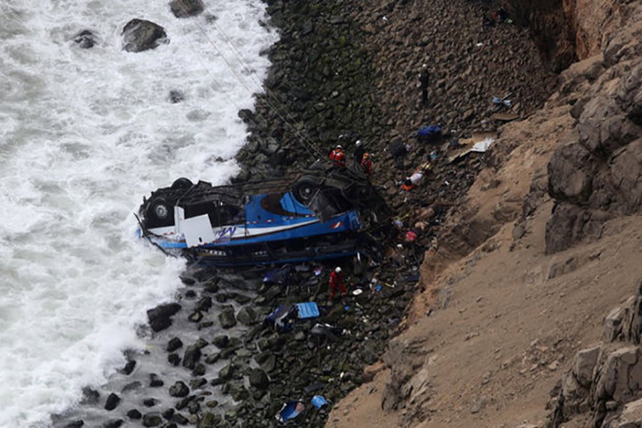 Rescue workers and police work at the scene after a bus crashed with a truck and careened off a cliff along a sharply curving highway north of Lima, Peru on Tuesday. - Reuters photo