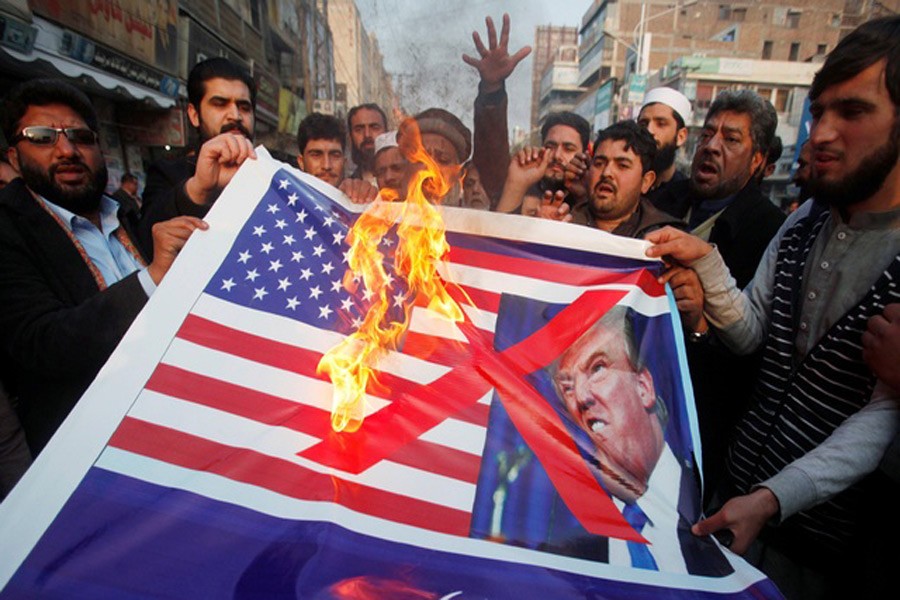 People burn a sign depicting a US flag and a picture of US President Donald Trump as they take part in an anti-US rally in Peshawar, Pakistan, Jan 5, 2018. Reuters