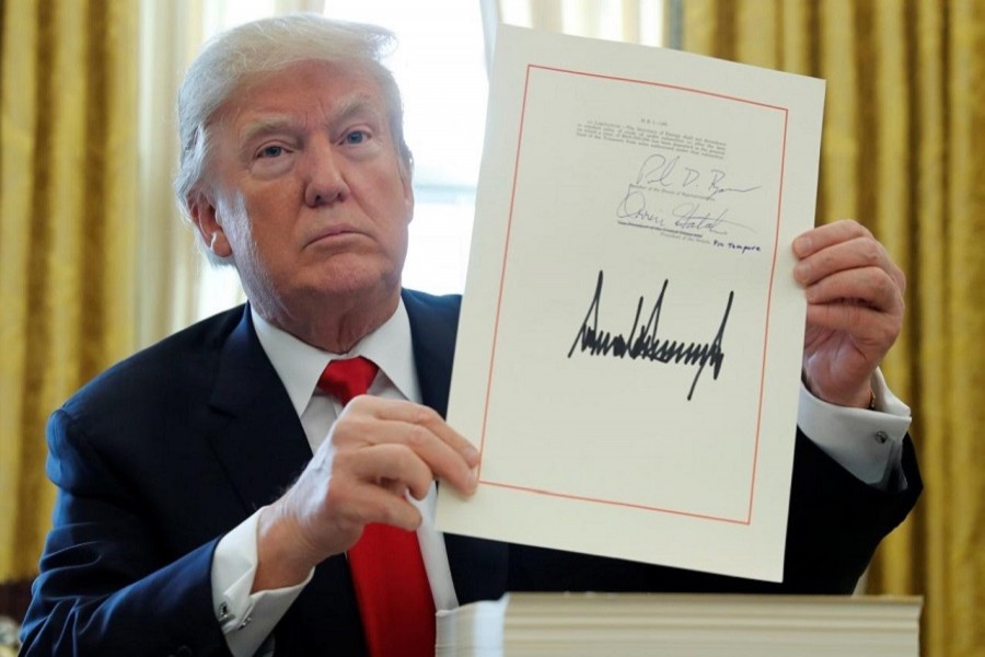 US President Donald Trump displays his signature after signing the $1.5 trillion tax overhaul plan in the Oval Office of the White House, December 22, 2017. Reuters/File Photo