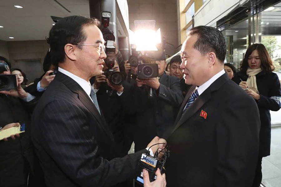 South Korea's Cho Myoung-gyon (left) shakes hands with the North's delegation head, Ri Son Gwon. - via AP