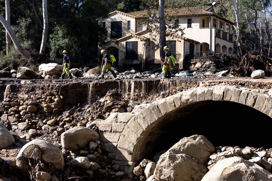 Firefighters walk on a road damaged by mudslides in Montecito, California, US on Wednesday. - Reuters photo