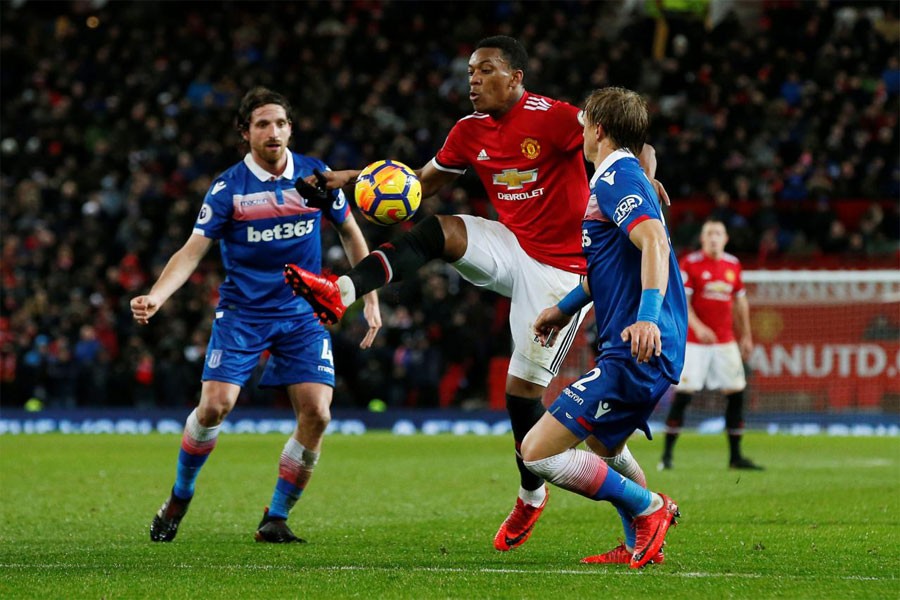 Premier League - Manchester United vs Stoke City - Old Trafford, Manchester, Britain - January 15, 2018. Manchester United's Anthony Martial in action with Stoke City’s Moritz Bauer and Joe Allen (REUTERS)