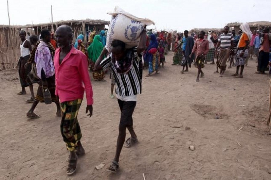 People walk away carrying food donation from a temporary centre in the drought-stricken Somali region in Ethiopia, January 26, 2016. Reuters/File Photo