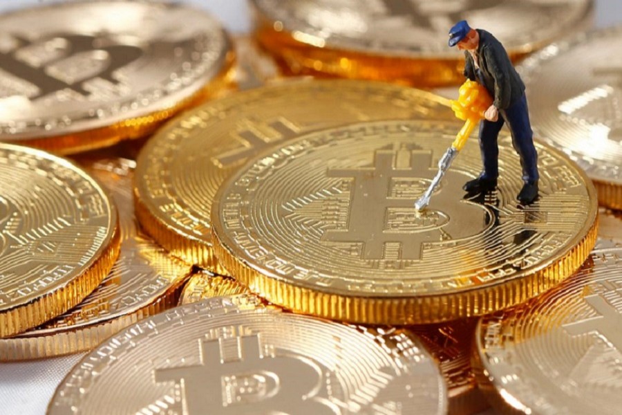 A small toy figure is seen on representations of the Bitcoin virtual currency in this illustration picture, December 26, 2017. Reuters/Files