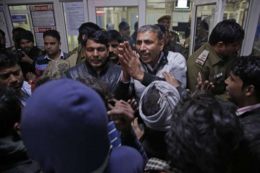 An unidentified hospital official pleads in front of the agitated relatives of firecracker factory fire victim, in a local hospital on the outskirts of New Delhi, India, early Sunday. - AP photo