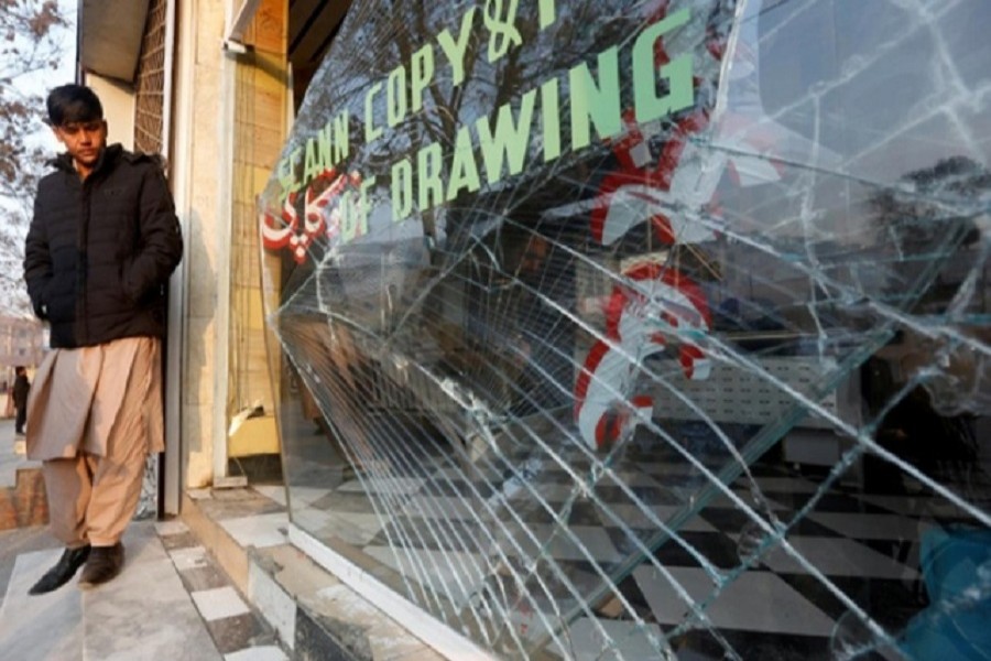 An Afghan shopkeeper looks at the broken glass window of his shop near the site of a bomb attack in Kabul, Afghanistan, Jan 28, 2018.  Reuters