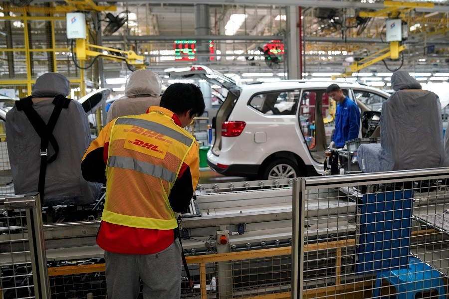 An employee of DHL company (yellow vest) works inside a Baojun car final assembly plant operated by General Motors Co. and its local joint-venture partners in Liuzhou, Guangxi Zhuang Autonomous Region, China, December 27, 2017. Reuters/File Photo