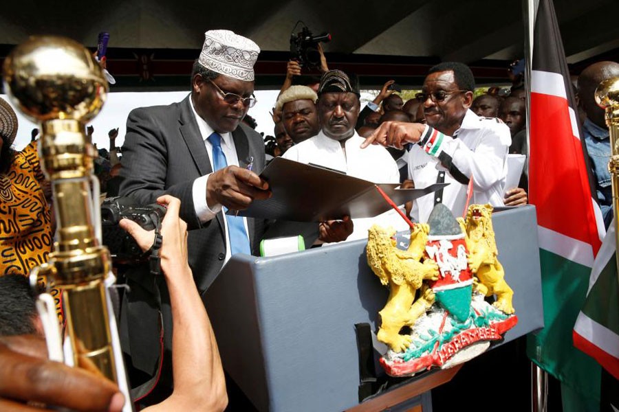 Kenyan opposition leader Raila Odinga (C) of the National Super Alliance (NASA) is assisted by lawyer Miguna Miguna (L) and James Orengo as he takes a symbolic presidential oath of office in front of his supporters in Nairobi, Kenya January 30, 2018. (REUTERS)