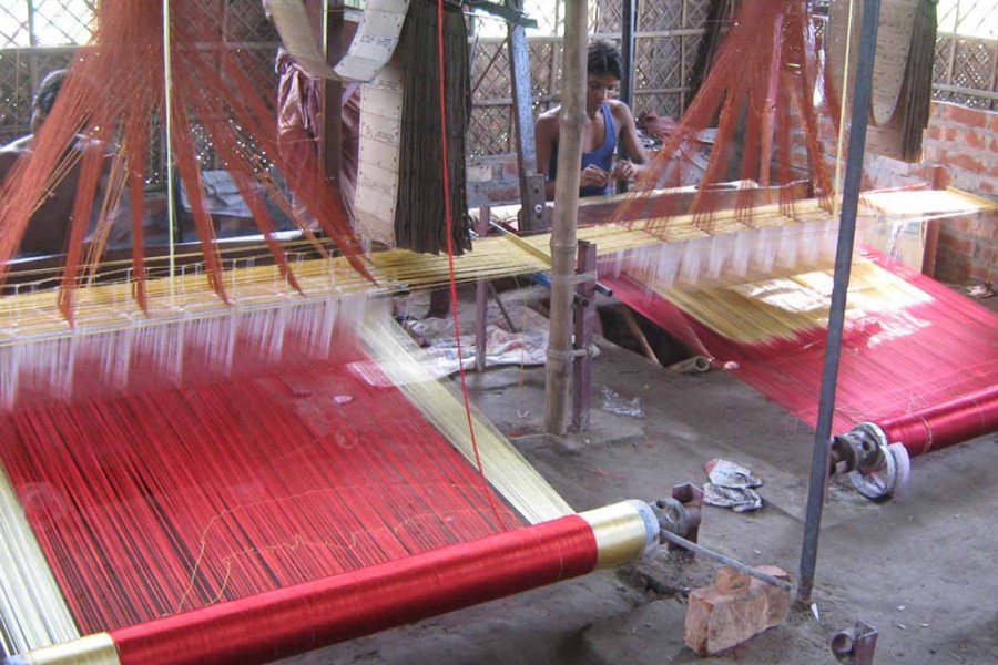 Two artisans weave Benarasi sarees at a factory in Habu Tantipara village under Gangachara upazila of Rangpur on Thursday.  	— FE Photo
