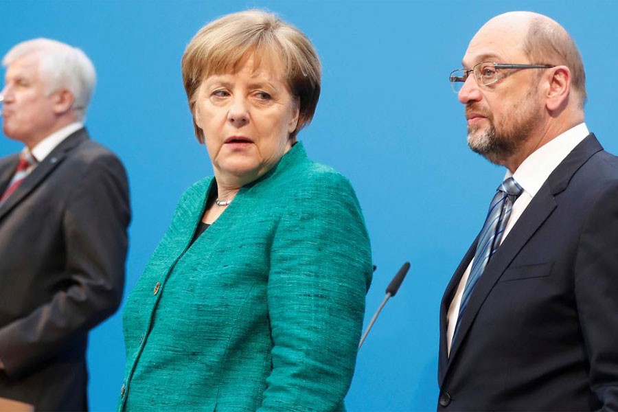Christian Democratic Union (CDU) leader and German Chancellor Angela Merkel, Christian Social Union (CSU) leader Horst Seehofer and Social Democratic Party (SPD) leader Martin Schulz pose after a statement on coalition talks to form a new coalition government in Berlin, Germany, February 7, 2018. (REUTERS)