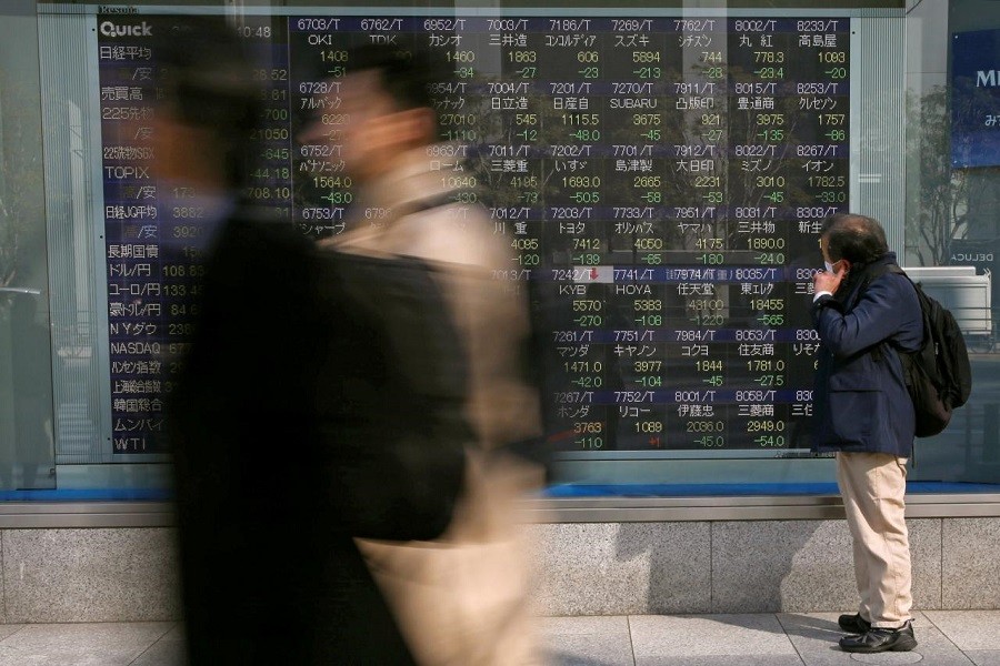 A man looks at an electronic stock quotation board outside a brokerage in Tokyo, Japan February 9, 2018. Reuters