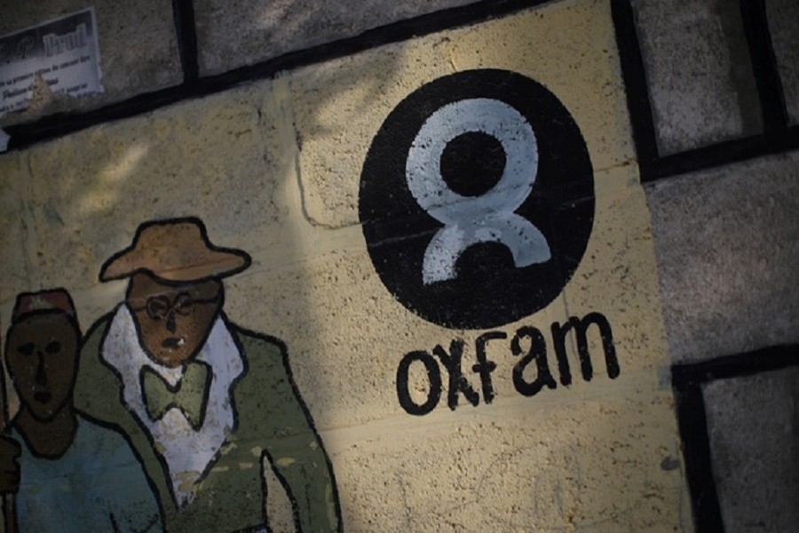 An Oxfam sign is seen on a wall in Corail, a camp for displaced people of the earthquake of 2010, on the outskirts of Port-au-Prince, Haiti, Feb 17, 2018. Reuters