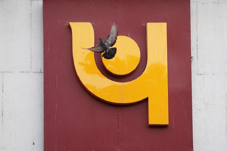 A pigeon flies past the logo of Punjab National Bank outside a branch of the bank in New Delhi, India February 15, 2018. Reuters