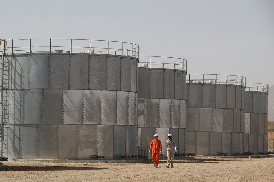 Workers walk past storage tanks at Tullow Oil's Ngamia 8 drilling site in Lokichar, Turkana County, Kenya, February 8, 2018. Reuters