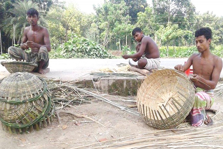 Artisans busy making bamboo items in Charmohor upazila of Pabna on Tuesday. 	— FE Photo