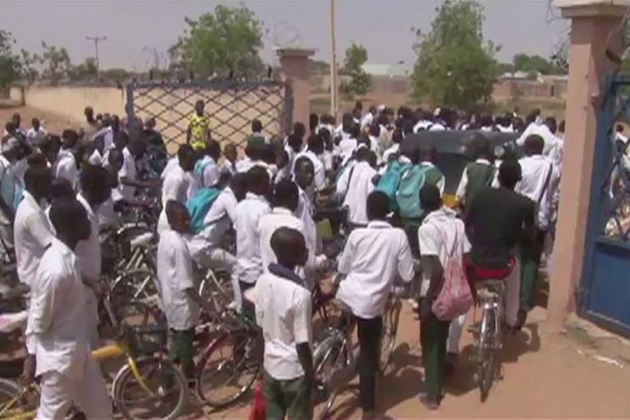 In this image from TV, students steam through the school security gates as they leave school, in Damaturu, Nigeria, Monday Feb. 26, 2018.  - AP