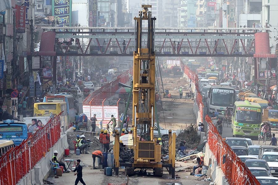 Metro-rail construction squeezes the scope of vehicular movement on the busy road from Mirpur to Agargaon in the capital, intensifying gridlock in the areas.— FE Photo by KAZ Sumon