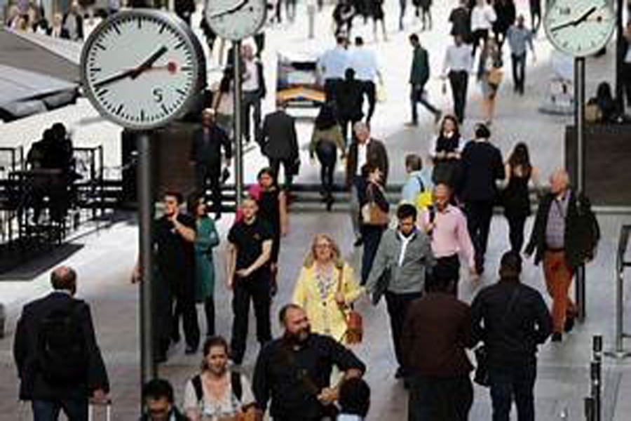 People walk through the financial district of Canary Wharf, London, Britain. 	— Reuters