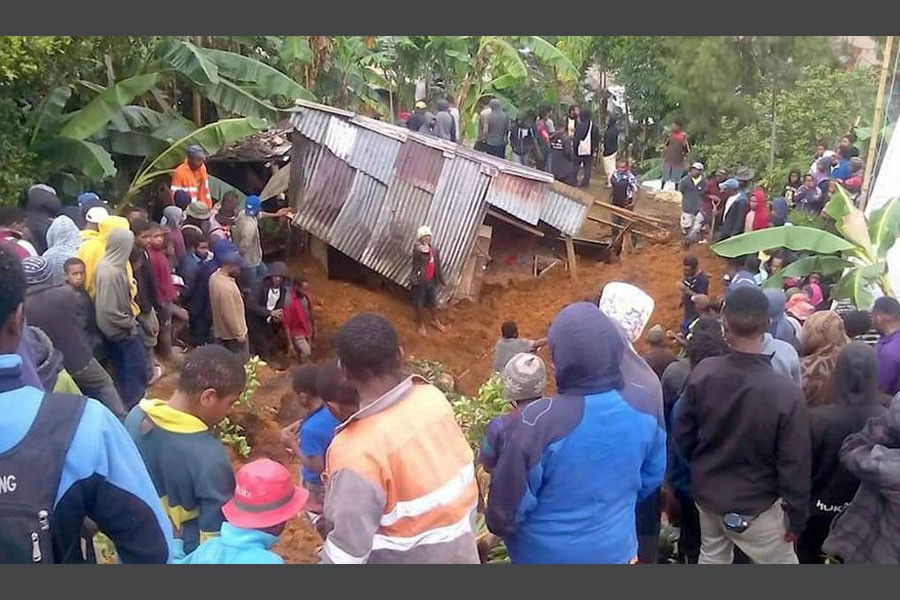 Locals surround a house that was covered by a landslide in the town of Mendi after an earthquake struck Papua New Guinea's Southern Highlands in this image taken on February 27, 2018 obtained from social media. (Reuters)