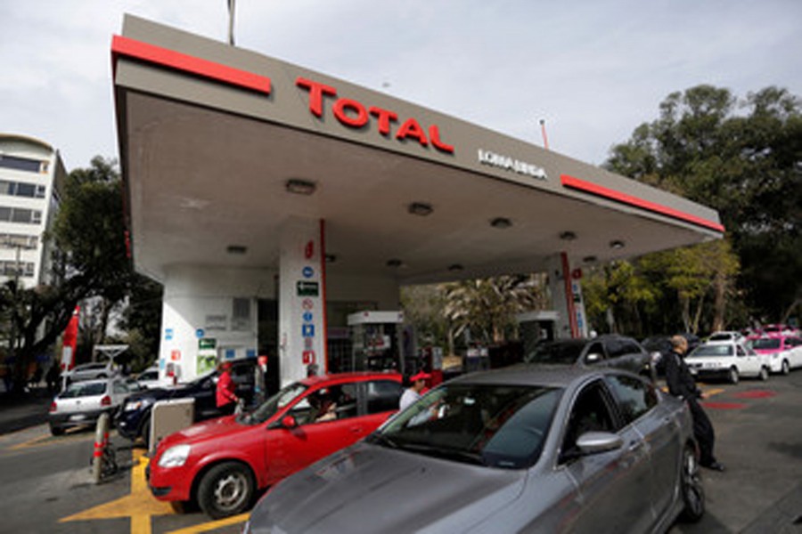 An employee pumps fuel into a customer's car at French oil giant Total's first gas station in Mexico City, Mexico. 	— Reuters