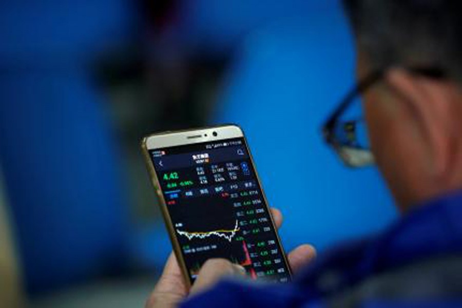 An investor checks stock information on a mobile phone at a brokerage house in Shanghai, China recently. Reuters/File Photo